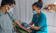 phlebotomist drawing blood from patient